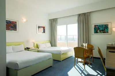 a hotel room with two beds and a desk at Petra Palace Hotel in Wadi Musa