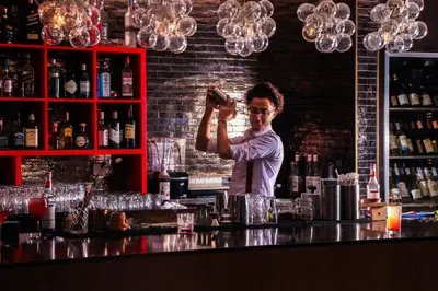 a man standing behind a bar preparing a drink at Hyatt Regency Aqaba Ayla Resort in Aqaba