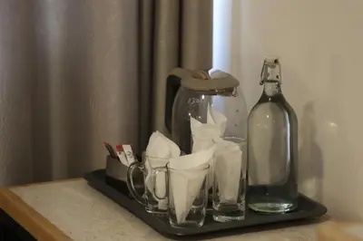 a tray with cups and a bottle on a table at Nomads Hotel in Amman