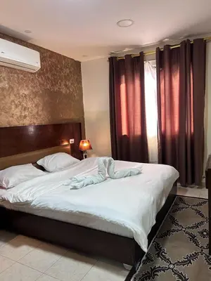 a bedroom with a large bed with white sheets at Robou Al Sharq in Amman
