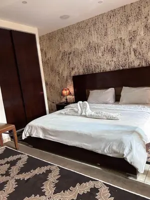 a bedroom with a large bed with a wooden headboard at Robou Al Sharq in Amman