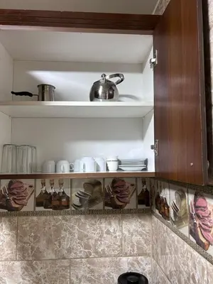a kitchen shelf with cups and dishes on it at Robou Al Sharq in Amman