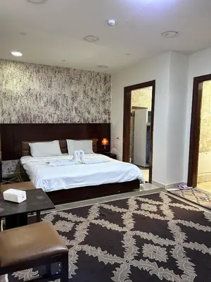 a bedroom with a large white bed and a rug at Robou Al Sharq in Amman