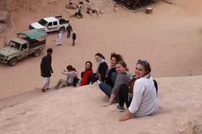 a group of people sitting on the sand at Bedouin Expedition in Wadi Rum