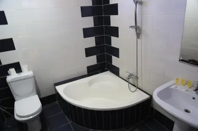 a bathroom with a tub and a toilet and a sink at Ajnadeen Hotel in Irbid