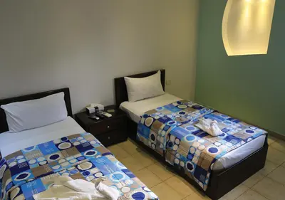 two beds sitting next to each other in a room at Ajnadeen Hotel in Irbid