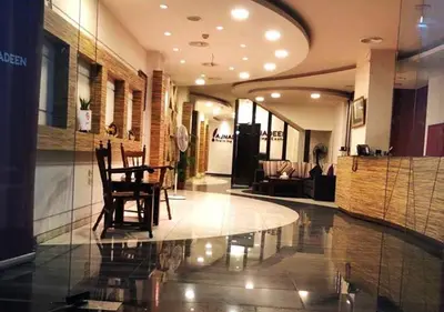 a lobby with chairs and a table in a building at Ajnadeen Hotel in Irbid