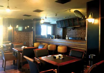 a restaurant with tables and chairs and a bar at Ajnadeen Hotel in Irbid