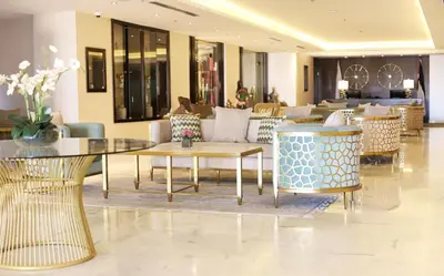a lobby with tables and chairs in a building at The SanRock Hotel in Amman