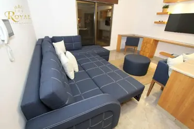 a living room with a blue couch and a table at Royal Luxury Apartments & Studios in Amman