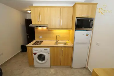 a small kitchen with a sink and a washer at Royal Luxury Apartments & Studios in Amman