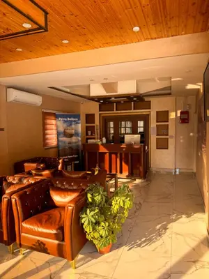 a lobby with leather couches and a desk at Petra Sky Hotel in Wadi Musa