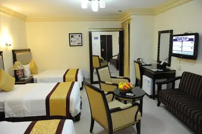 a hotel room with two beds and a television at Cedar Hotel in Aqaba