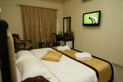 a bedroom with a bed with a tv on the wall at Cedar Hotel in Aqaba