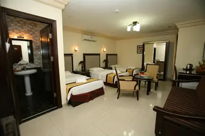 a hotel room with two beds and a sink at Cedar Hotel in Aqaba