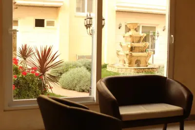 a view of a chair and a fountain through a window at Western Gate Residence 2 Amman in Amman