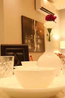 a white vase with a flower in it on a table at Western Gate Residence 2 Amman in Amman