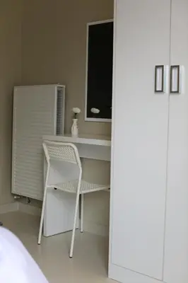 a white desk with a chair and a window at Western Gate Residence 2 Amman in Amman