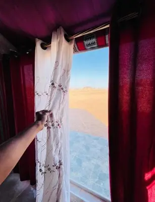a person is opening a curtain on a train at Miral Night Camp in Wadi Rum