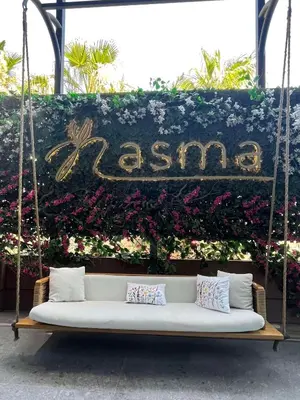 a white couch on a swing in front of flowers at Hilton Amman in Amman