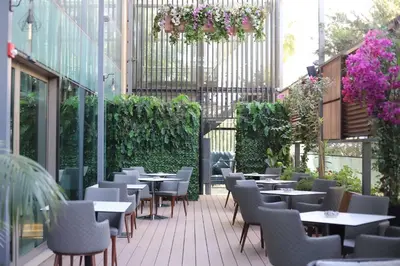 a restaurant with tables and chairs on a patio at Hilton Amman in Amman