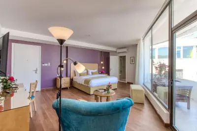 a hotel room with a bed and a blue chair at The Liwan Hotel in Amman
