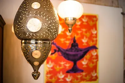 a lamp with a clock on a wall with a painting at The Liwan Hotel in Amman