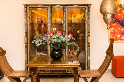 a dining room table with a vase of flowers at The Liwan Hotel in Amman