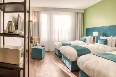 a hotel room with three beds with blue accents at The Liwan Hotel in Amman