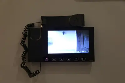 a television attached to a wall with a phone at Western Gate Residence 1 - Amman, Jordan in Amman