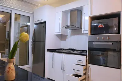 a kitchen with white cabinets and a stove top oven at Western Gate Residence 1 - Amman, Jordan in Amman