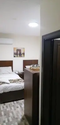 a room with two beds and a desk and a mirror at Darak hotel in Aqaba
