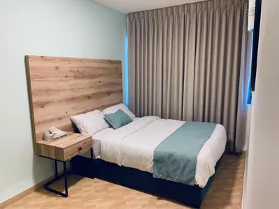 a bedroom with a bed with a wooden headboard at Crystal Hotel By FHM in Aqaba