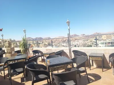 a row of tables and chairs on a patio at Petra Visitors Hotel in Wadi Musa