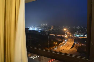 a view of a city at night from a window at Saray Hotel Amman in Amman