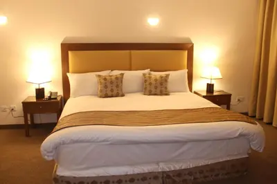a large bed in a hotel room with two lamps at Saray Hotel Amman in Amman
