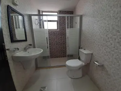 a bathroom with a toilet and a sink and a mirror at Furnished Apartments Near McDonald's Al-Madina Al-Monawara St in Amman