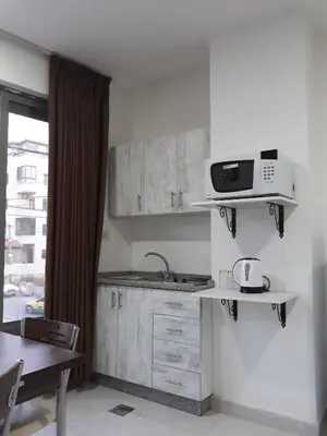 a kitchen with a sink and a microwave at Furnished Apartments Near McDonald's Al-Madina Al-Monawara St in Amman