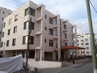 a building on the corner of a street at Furnished Apartments Near McDonald's Al-Madina Al-Monawara St in Amman