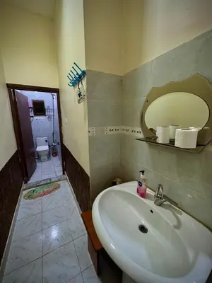 a bathroom with a sink and a mirror and a toilet at Al-Amer Hostel 1 in Aqaba