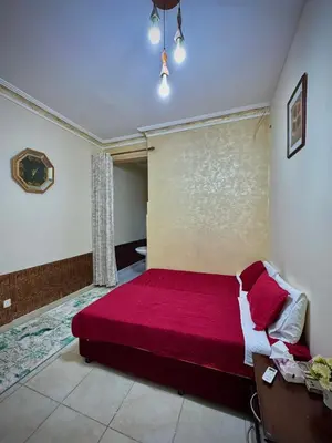 a bedroom with a large red bed in a room at Al-Amer Hostel 1 in Aqaba