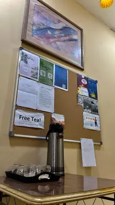 a coffee pot on a table with a free text on a wall at Al-Amer Hostel 1 in Aqaba