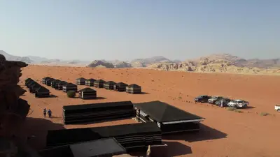 a group of buildings in a desert with mountains at Salem Camp in Wadi Rum