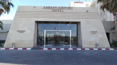 an amazon airport hotel building with a glass door at Amman Airport Hotel in Al Qasţal