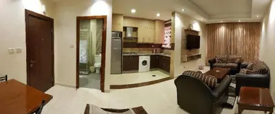 a living room with a couch and a table and a kitchen at Marmaris Hotel Apartments in Amman