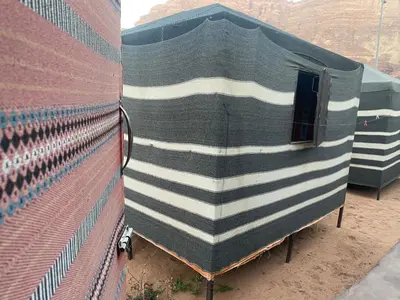 a side view of a green and white train at Bedouin Village Hostel in Wadi Rum