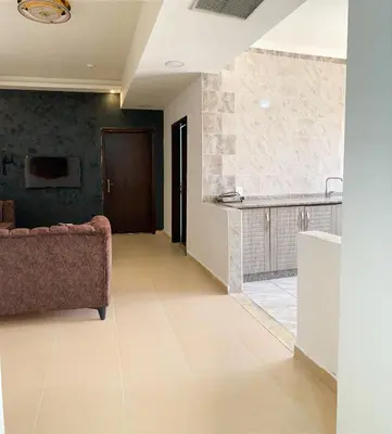 a living room with a couch and a counter at Skylight apartments in Amman