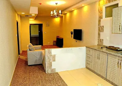 a living room with a kitchen with a couch and a television at Skylight apartments in Amman