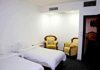 a hotel room with two beds and two chairs at Skylight apartments in Amman