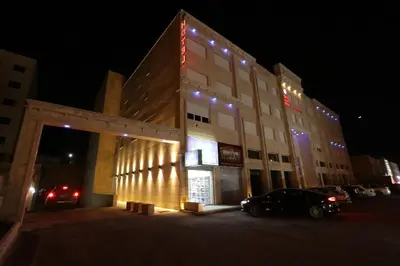 a building with a car parked in front of it at night at Skylight apartments in Amman